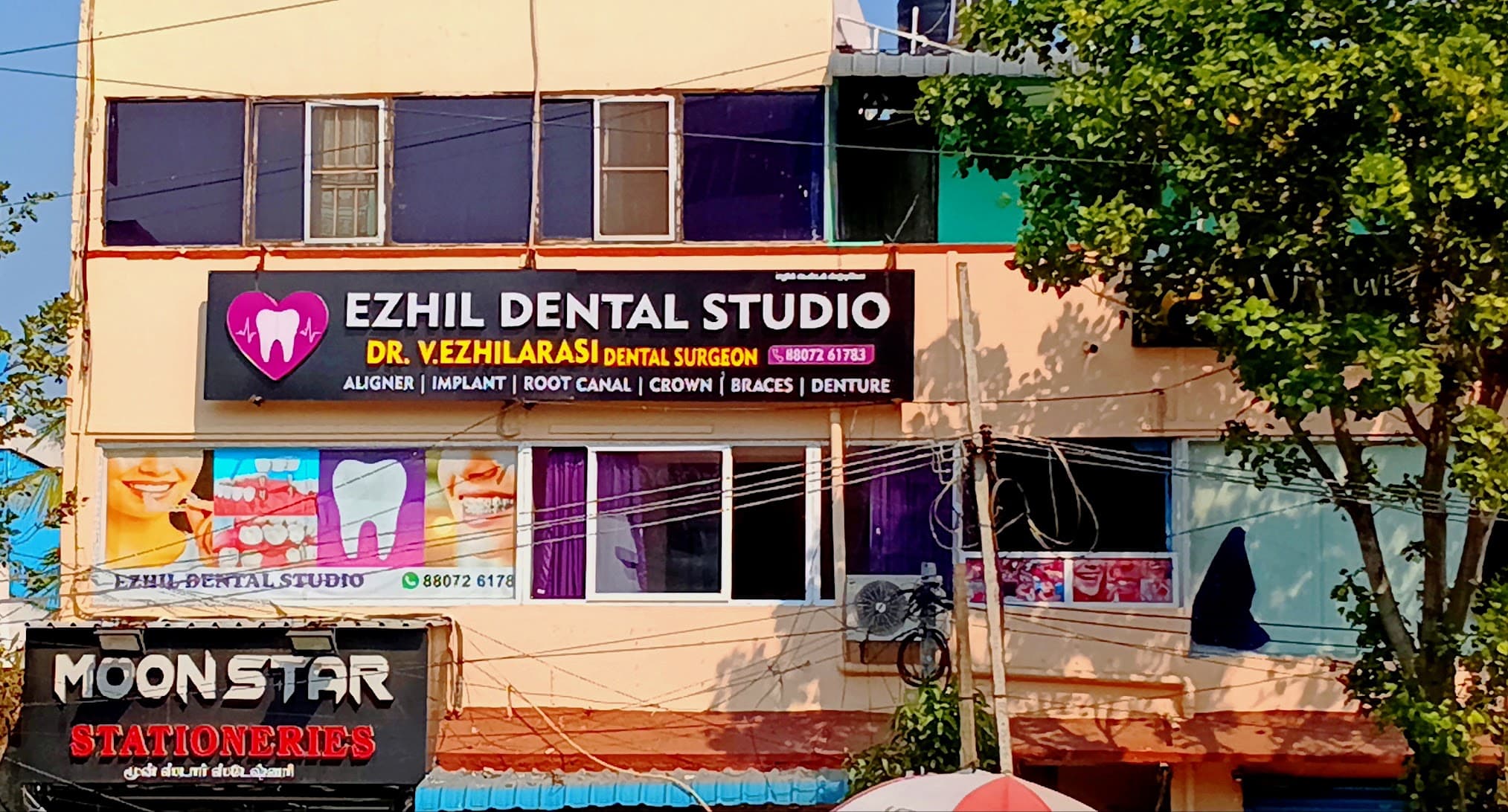 Ezhil Dental Studio signboard with the pink heart and tooth logo on the first floor of the building on Velachery Bypass Road