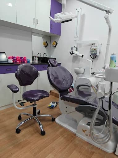 Treatment room at Ezhil Dental Studio with a dental chair and purple cabinets